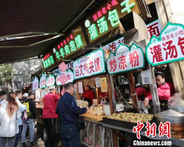 西安回民街云集了当地美食小吃,这些特色食物常出现在陕西文学作品中。胡宗峰团队将“羊肉泡馍”译为“Yangroupao”,后面加注“mutton broth with cubedbread”。中新社记者 张远 摄 西安回民街云集了当地美食小吃,这些特色食物常出现在陕西文学作品中。胡宗峰团队将“羊肉泡馍”译为“Yangroupao”,后面加注“mutton broth with cubedbread”。中新社记者 张远 摄