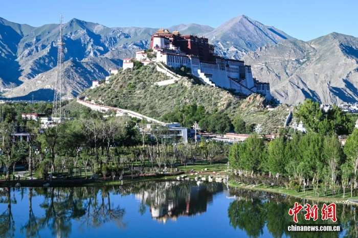 8月5日，随着西藏自治区成立60周年大庆临近，拉萨街头处处洋溢着喜庆氛围。市区主干道的路灯杆上，崭新的国旗与彩旗有序悬挂，鲜艳夺目。人行天桥完成升级改造，装饰板上国旗、石榴籽、牡丹花、浪潮、山川、连心结、雪山与哈达等元素相互交融，别具特色。工作人员正紧锣密鼓地布置花坛，五彩花卉将为城市增添斑斓色彩。此外，各大广场、公园也在装点，准备迎接八方来客。拉萨正以最美姿态，迎接这一重要时刻。图为从团结公园遥望布达拉宫。中新社记者贡嘎来松摄