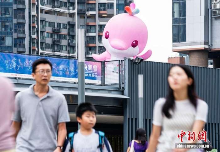 图为启德地铁站出口外的一尊吉祥物“乐融融”雕塑向过往市民“打招呼”。中新网记者侯宇摄